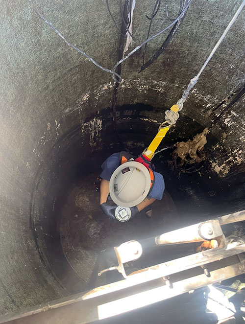 plumber enters sewage backup hole